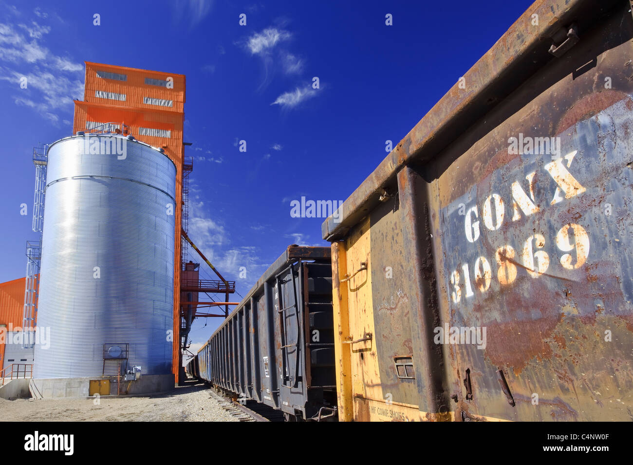Railway cars being loaded at a grain elevator.  Morse, Saskatchewan, Canada. Stock Photo