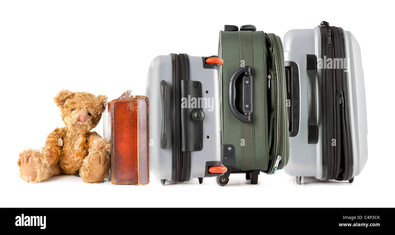 Idea for family travel with a row of different types of suitcase with a teddy bear at the end Stock Photo