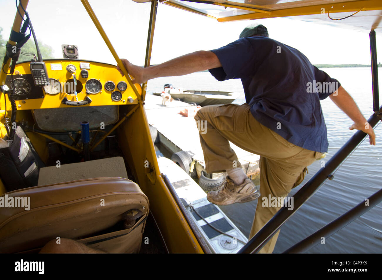 Pilot stepping out of his Piper Cub float plane, Gunn Lake, Ontario, Canada Stock Photo Alamy