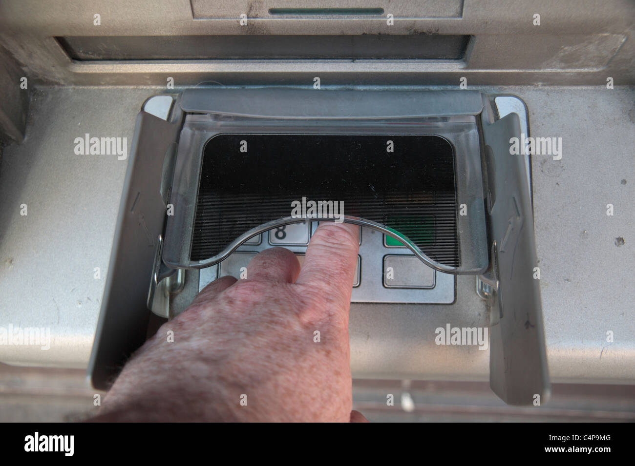 Entering a PIN number under a security screen to prevent onlookers