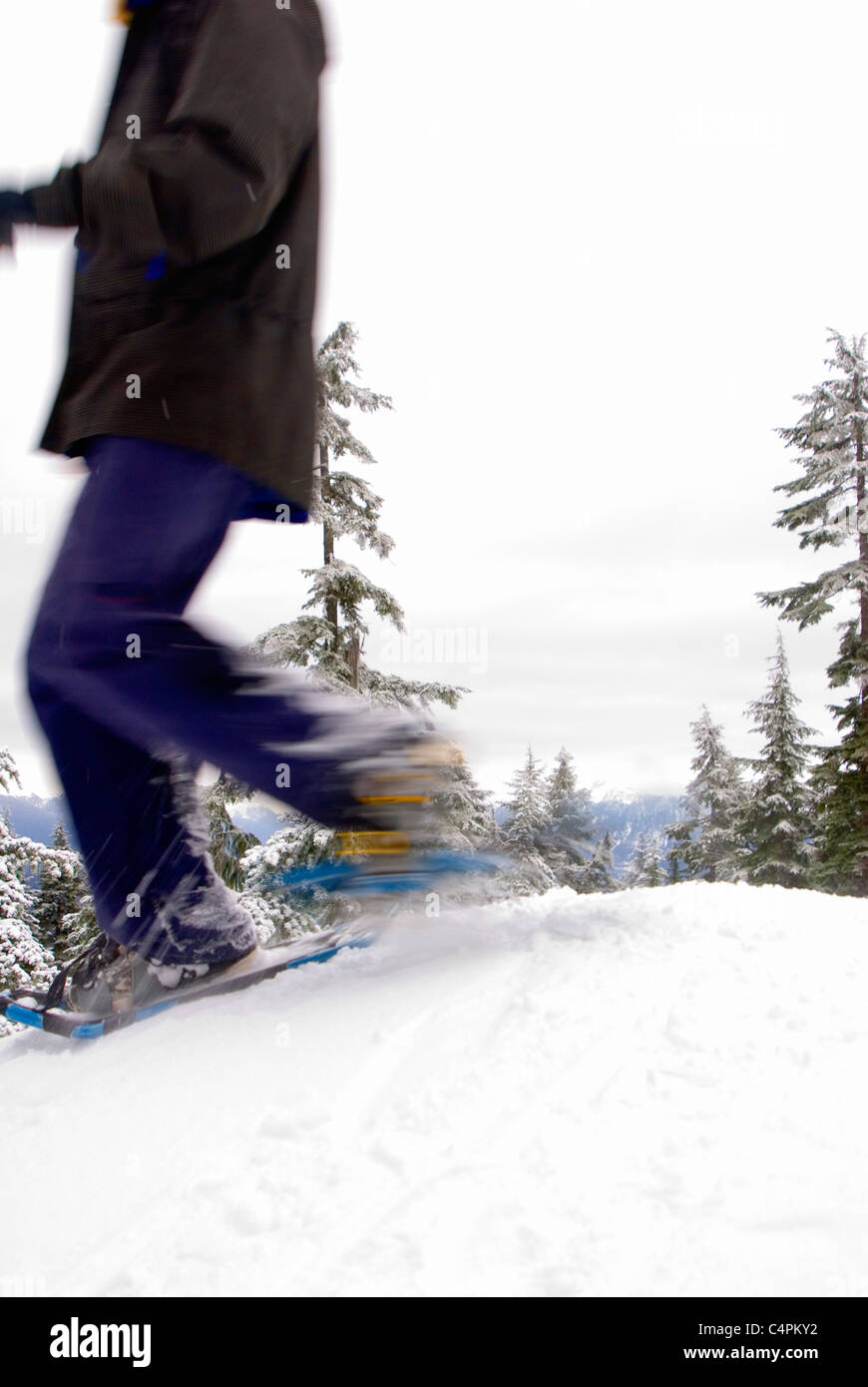 Woman running on snowshoes at Hollyburn Peak, Cypress Provincial Park