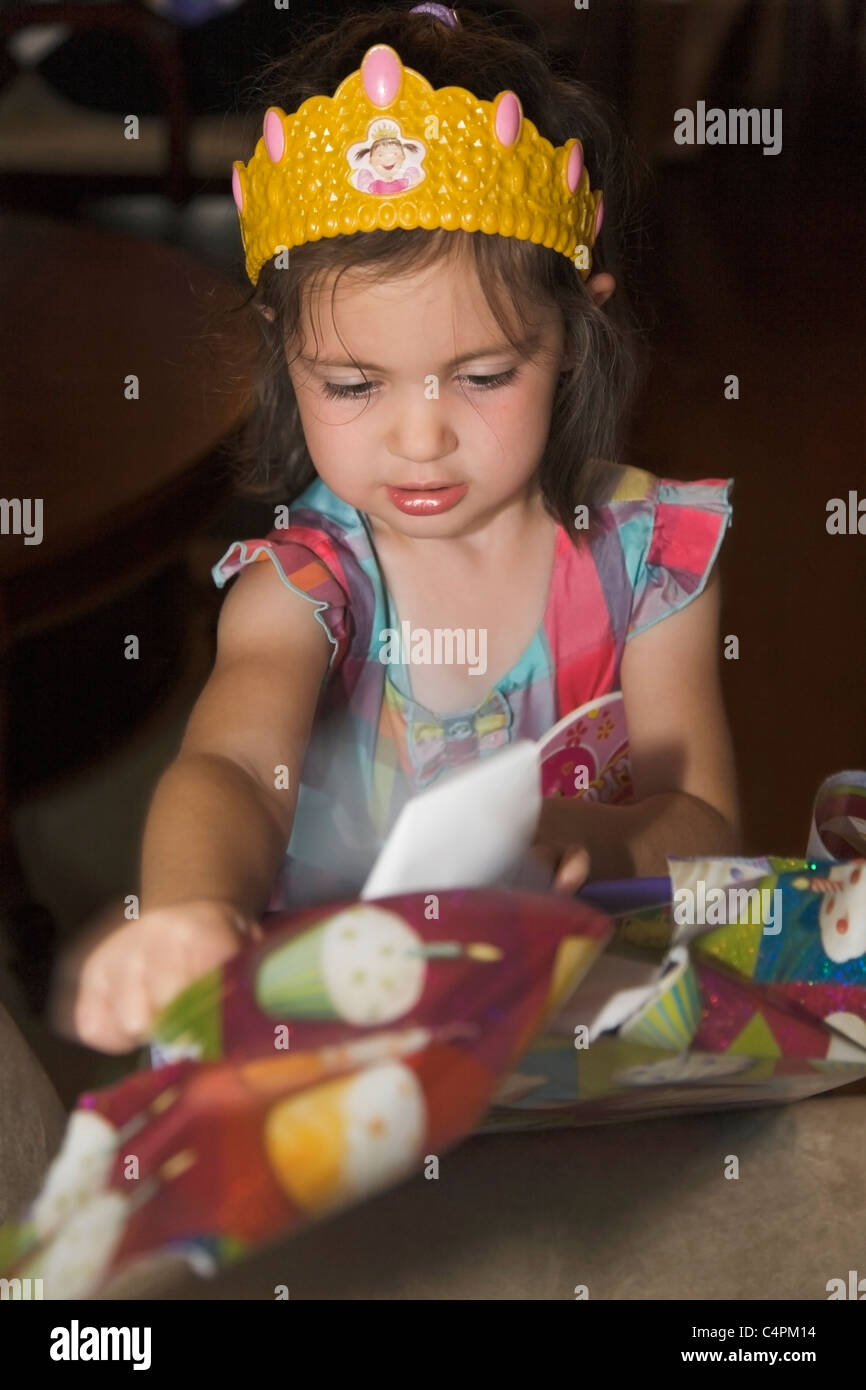 Four-year-old girl girl opening a birthday present, Ontario, Canada Stock Photo
