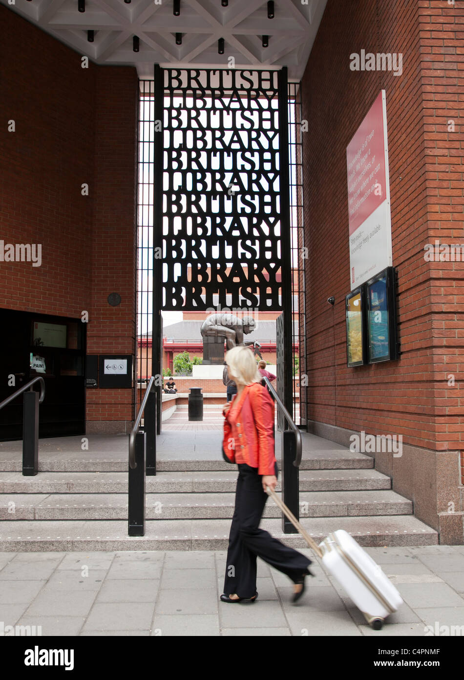 A woman walks past the entrance to the British Library Stock Photo