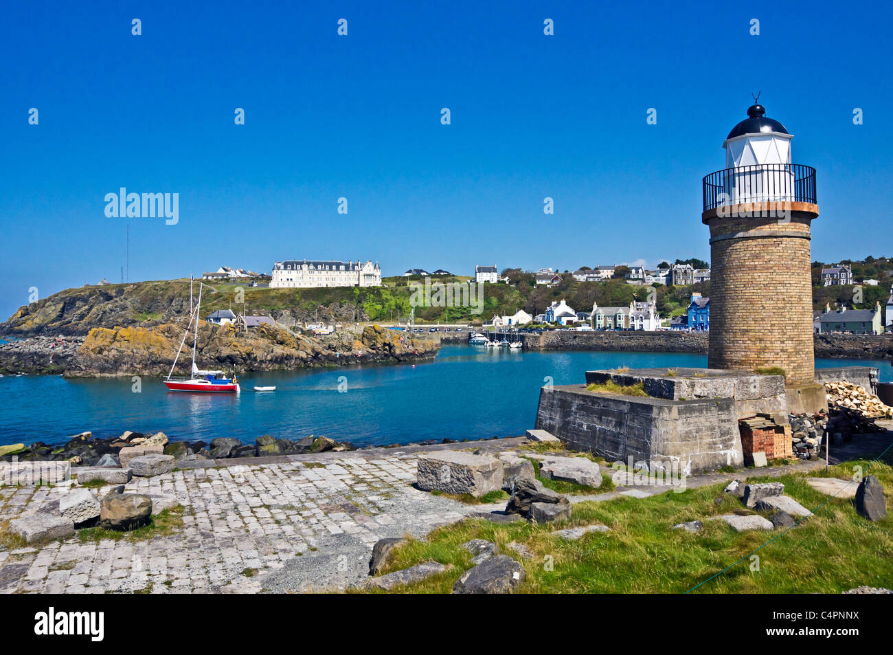 Portpatrick harbour in Dumfries & Galloway Scotland  with the old lighthouse at the entrance and Portpatrick Hotel left Stock Photo