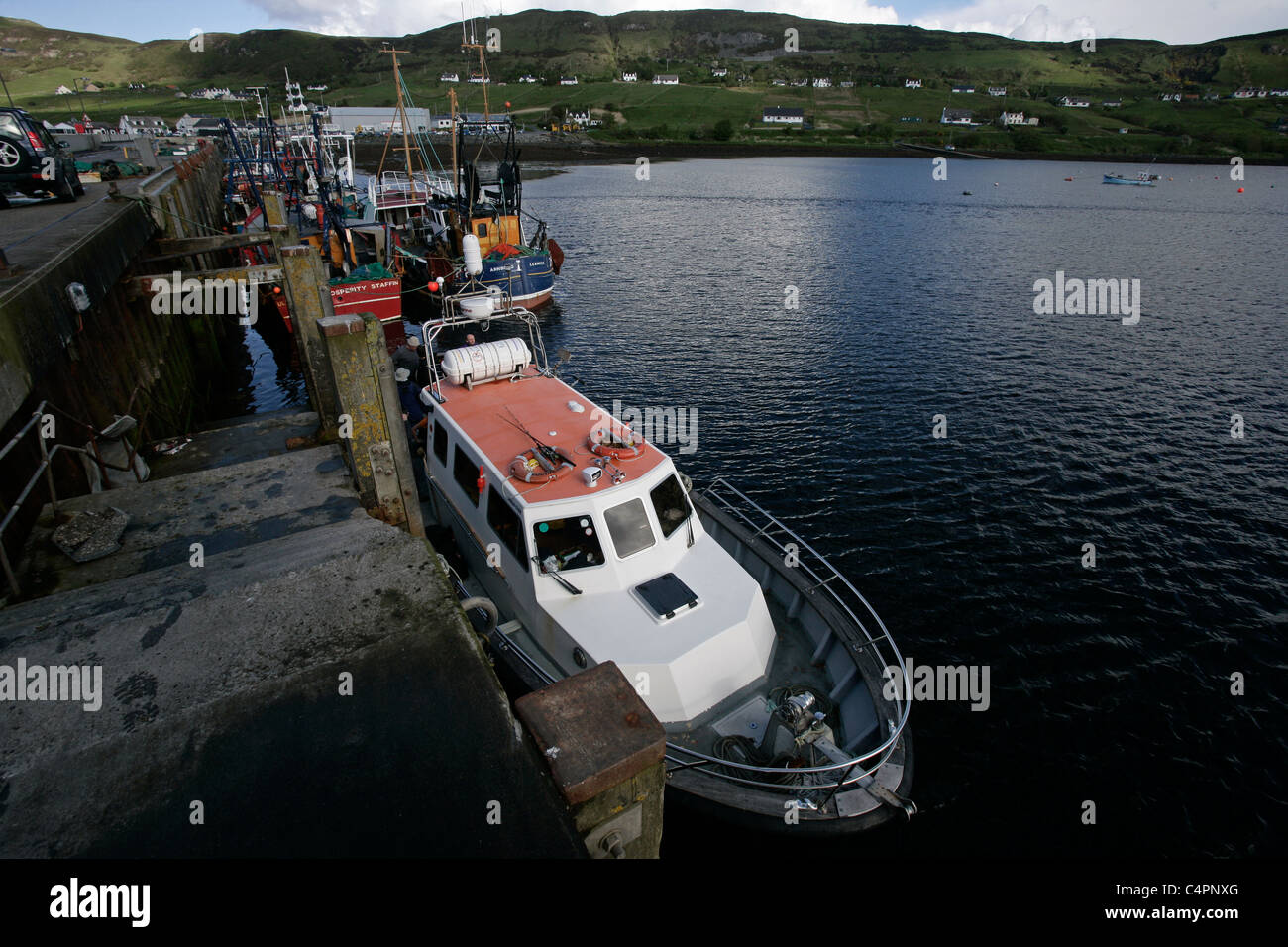 A dive boat and fishing boats tied up at the pier at Uig on the Isle of Skye, Inner Hebrides