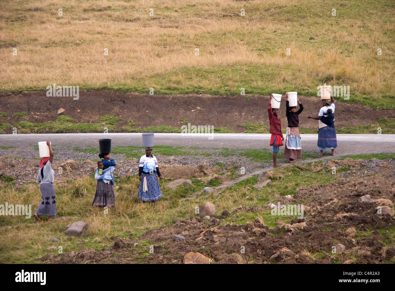 Local African women carrying babies as well as heavy loads on their heads, Transkei, South Africa Stock Photo