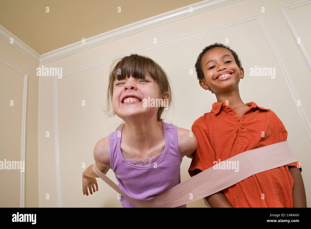 Young sister and brother joined by a large bandage Stock Photo - Alamy