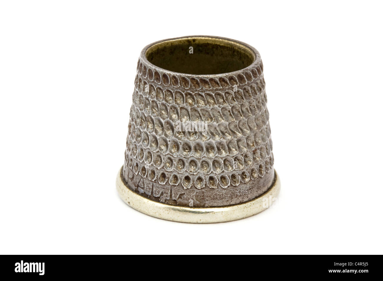 Close up of an old silver thimble over white Stock Photo