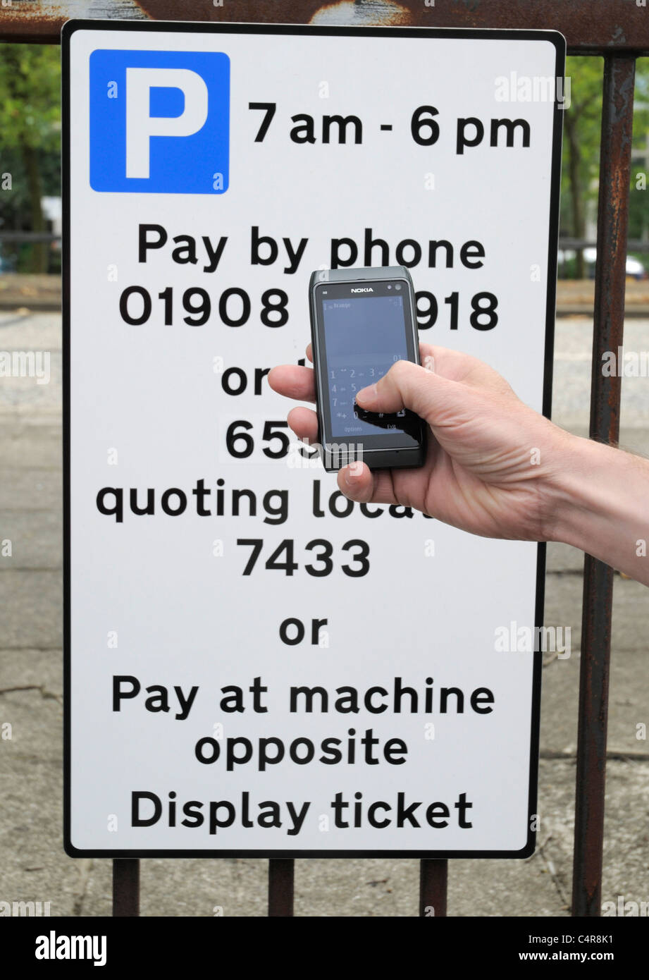 Pay By Mobile Phone Sign with Man Holding Mobile Phone in his Hand