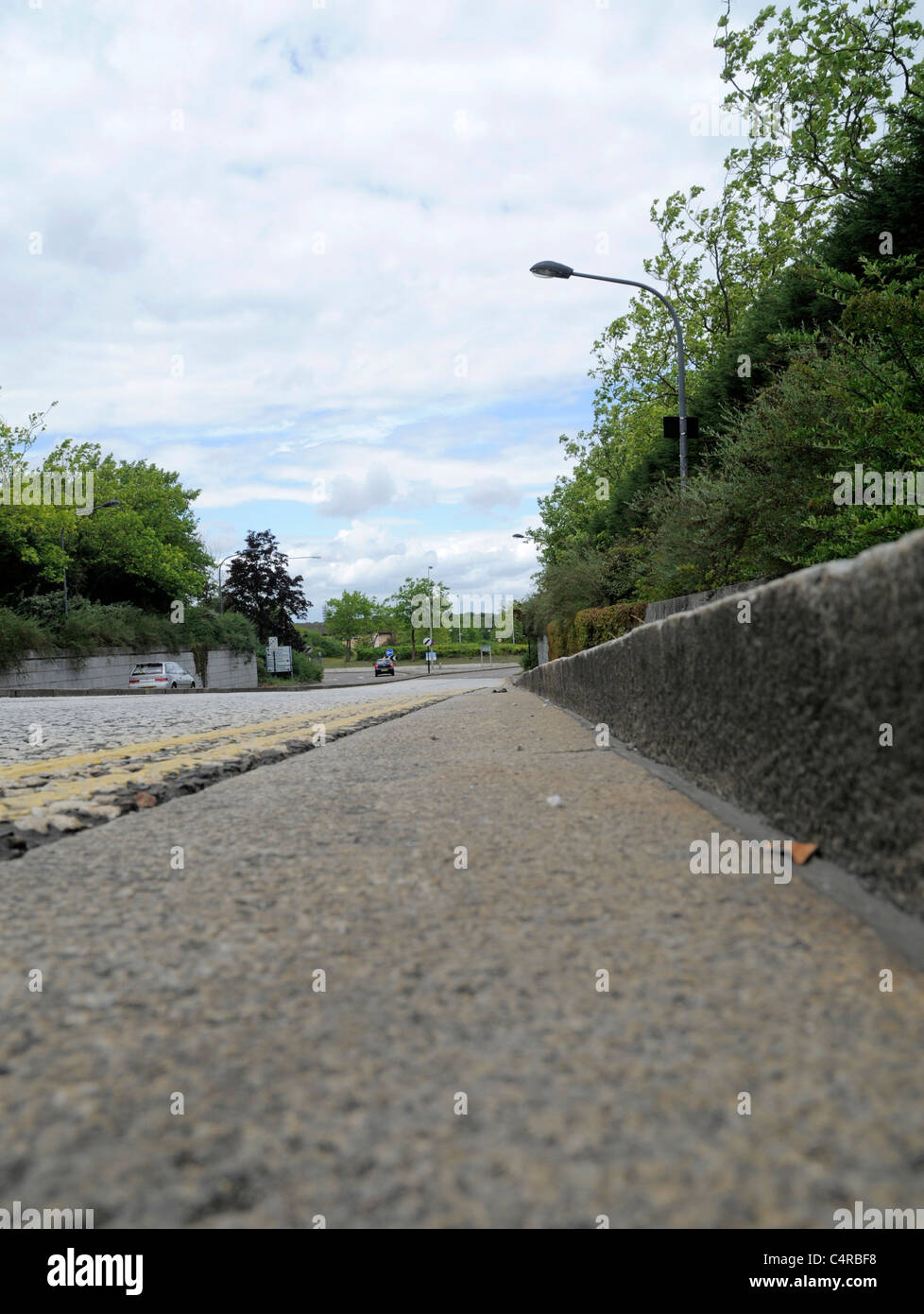 Low Level Angle Looking Down Pavement or Sidewalk Curb at Edge of Road Stock Photo