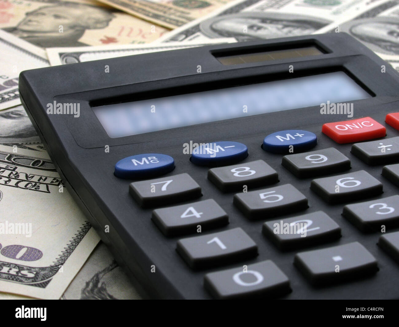 calculating income: calculator on heap of banknotes Stock Photo