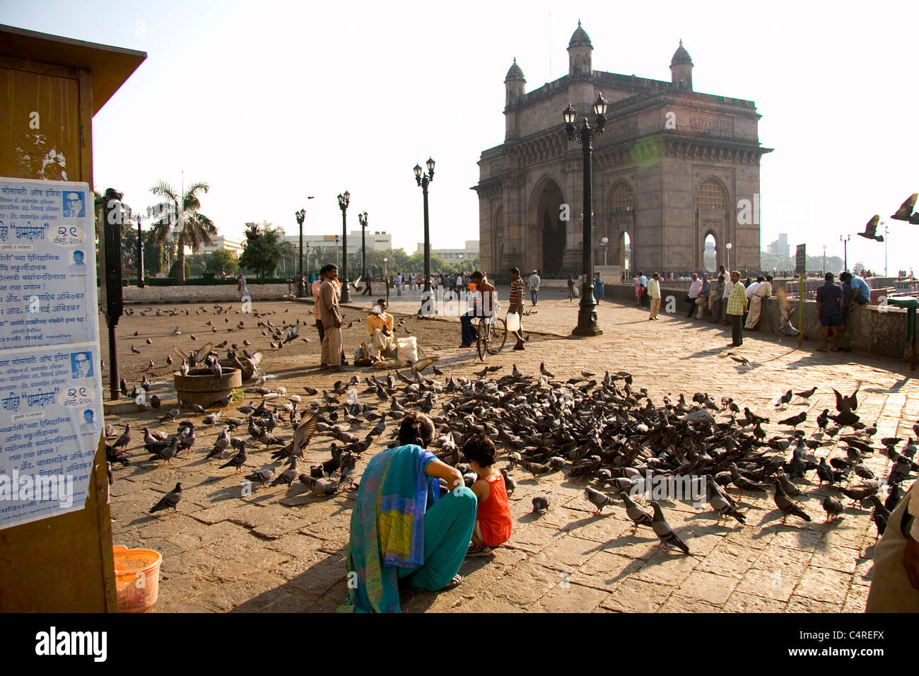 Indian mother and daughter feeding birds in the shadows of the Gateway