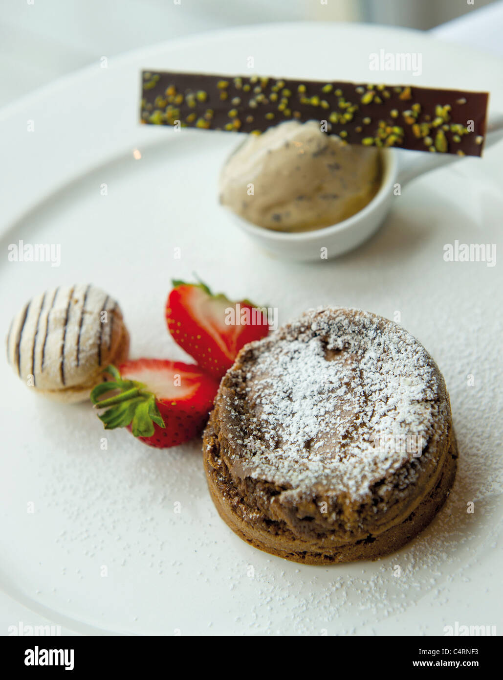 Valhona dark chocolate foundant desert, with espresso ice-cream and vanilla macaroon food Stock Photo