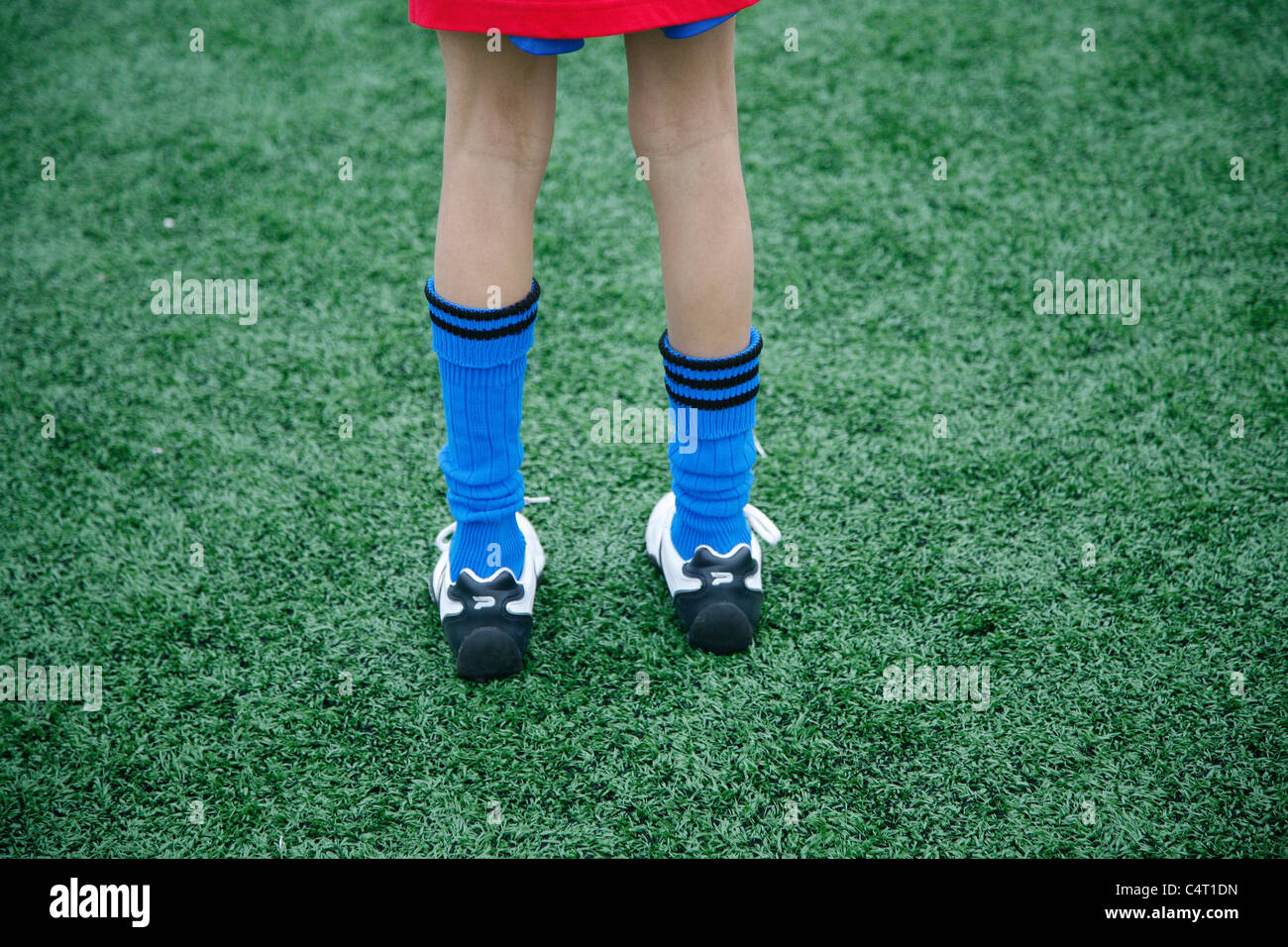young footballers legs while stood on pitch Stock Photo