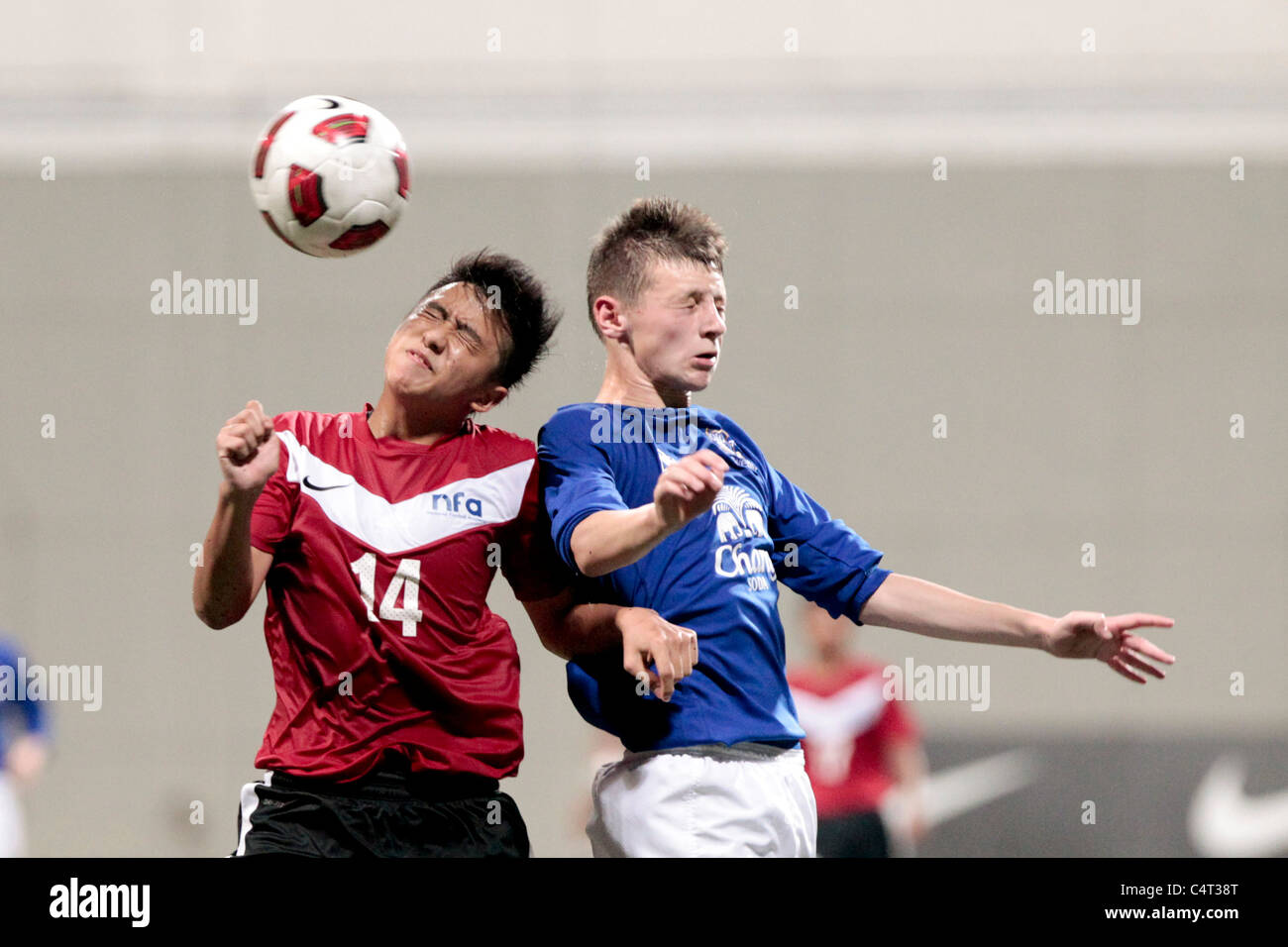 Illyas Lee of Singapore U16(left) and Calum Dyson battle for the aerial ball during the 23rd Canon Lion City Cup. Stock Photo