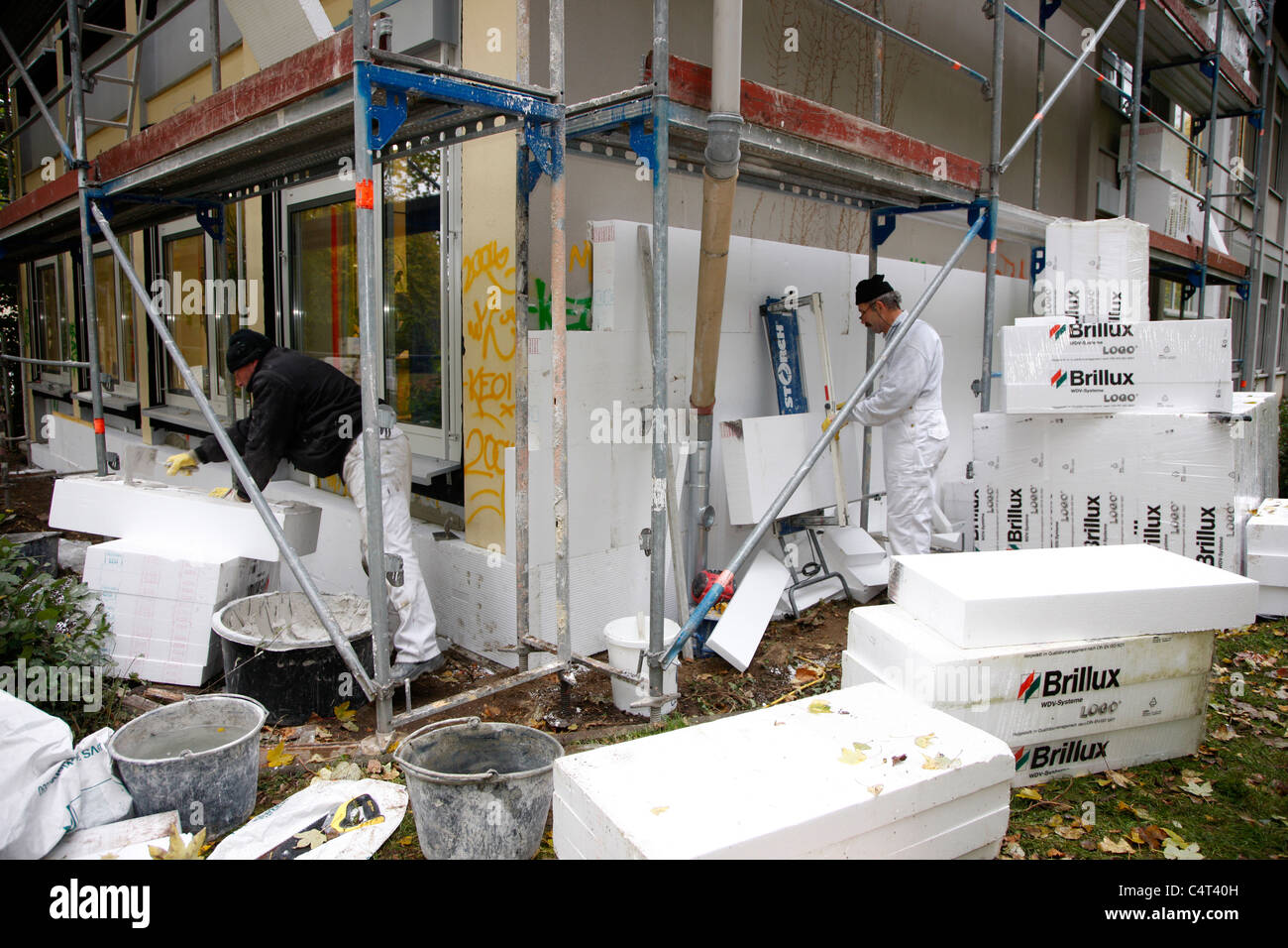 Heat insulation of a building. For saving energy, Styrofoam panels are sticked to the outside wall, to keep the warmth inside. Stock Photo