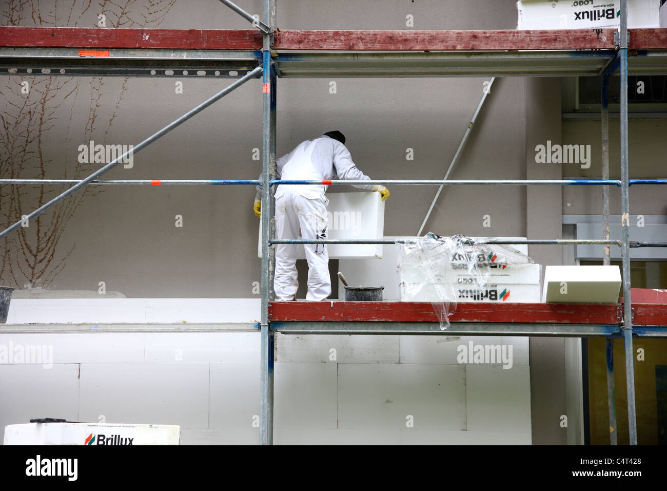 Heat insulation of a building. For saving energy, Styrofoam panels are sticked to the outside wall, to keep the warmth inside. Stock Photo