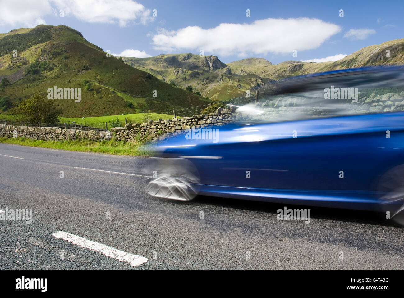 Blue car speeding on the A592, Lake District National Park, UK Stock Photo