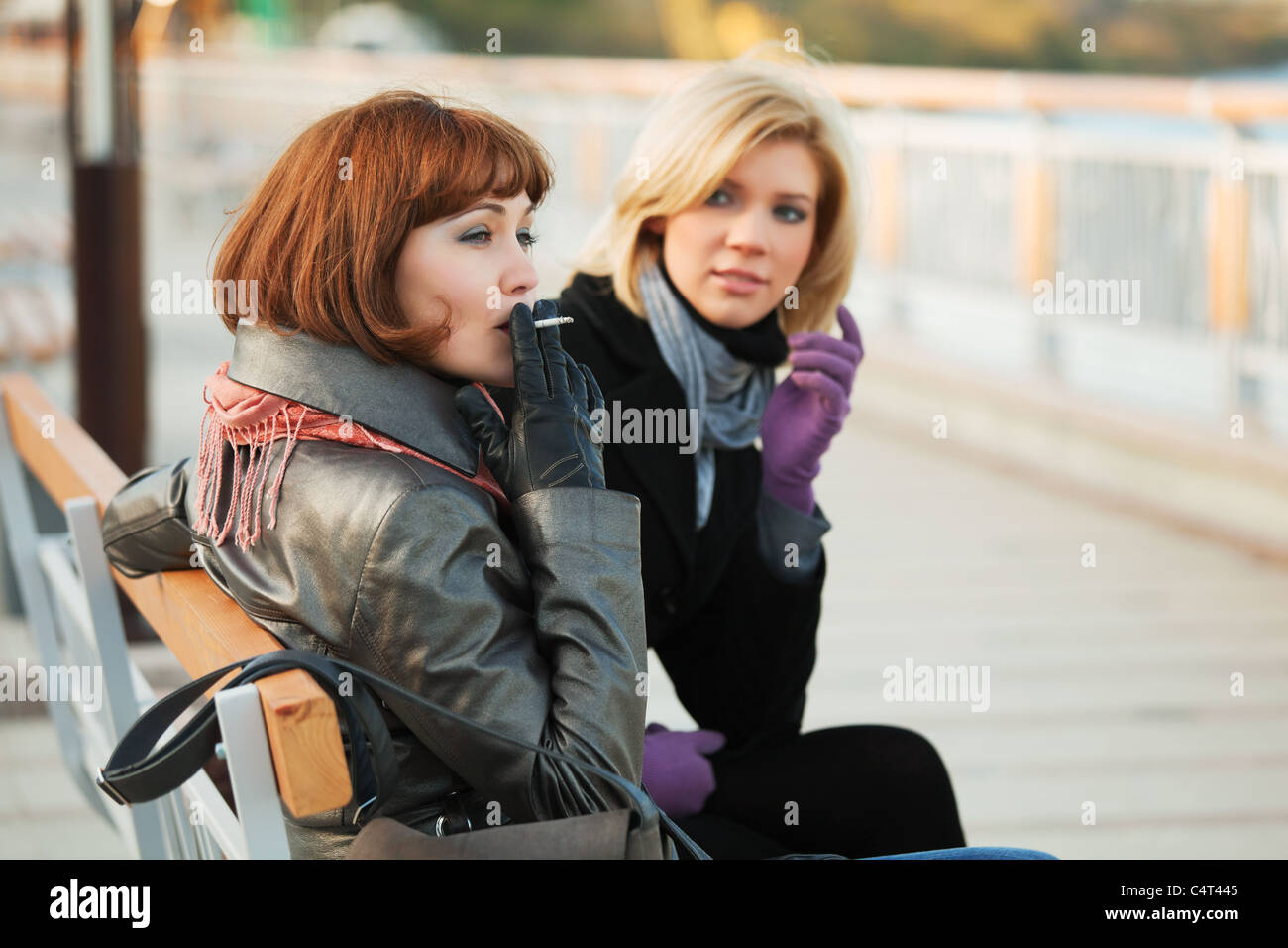 Two young women sitting on a bench Stock Photo