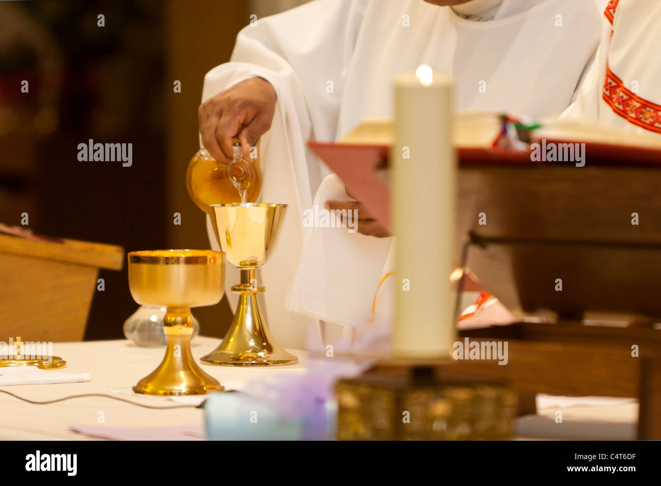 Catholic Mass and a priest holding a chalice during the religious ceremony. Stock Photo