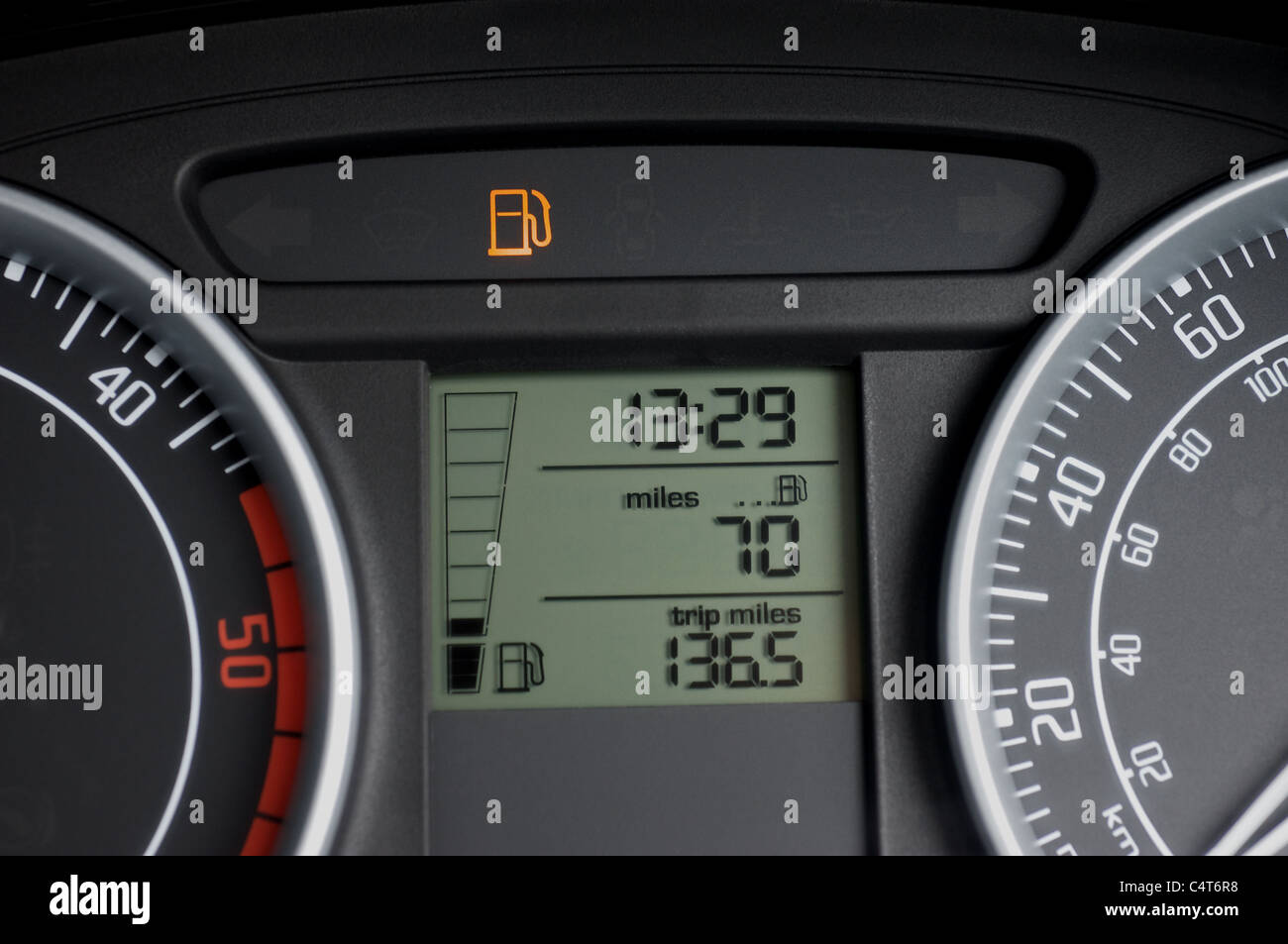 Car dashboard showing low fuel warning light Stock Photo