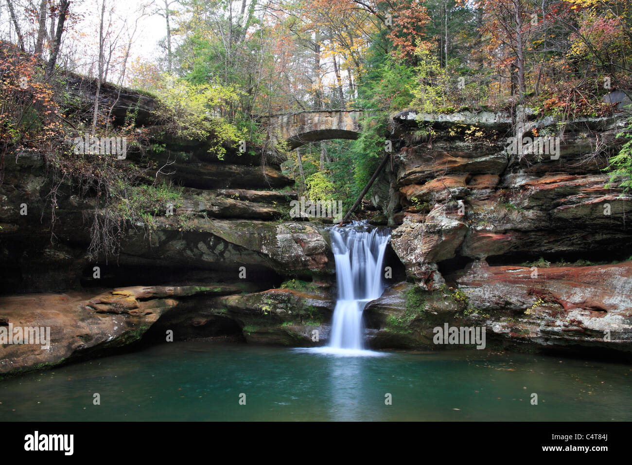 A Waterfall And Stone Foot Bridge In The Scenic Old Man's Cave State