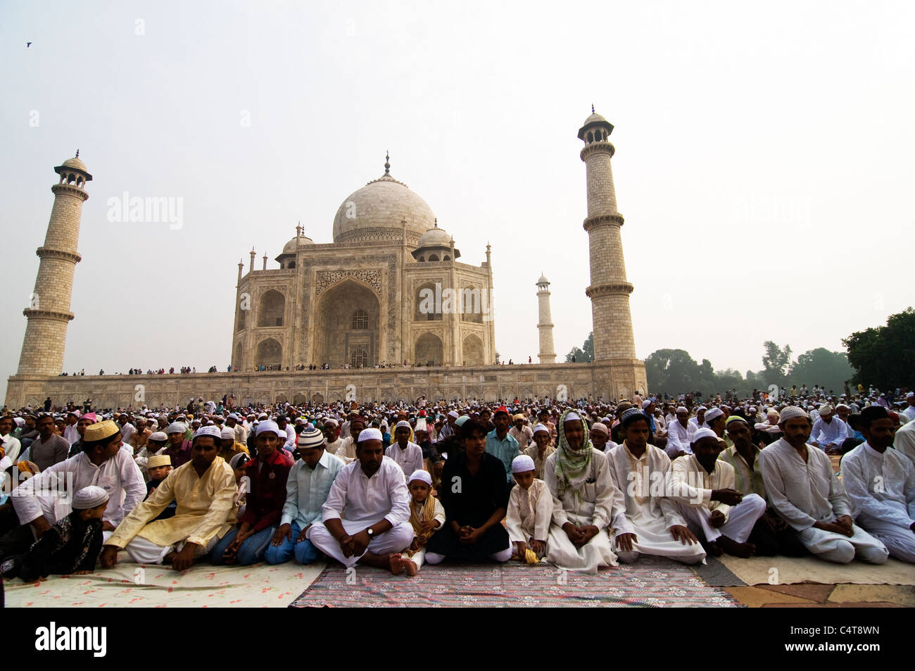 Muslim men pray by the mosque next to the Taj Mahal in Agra. Stock Photo