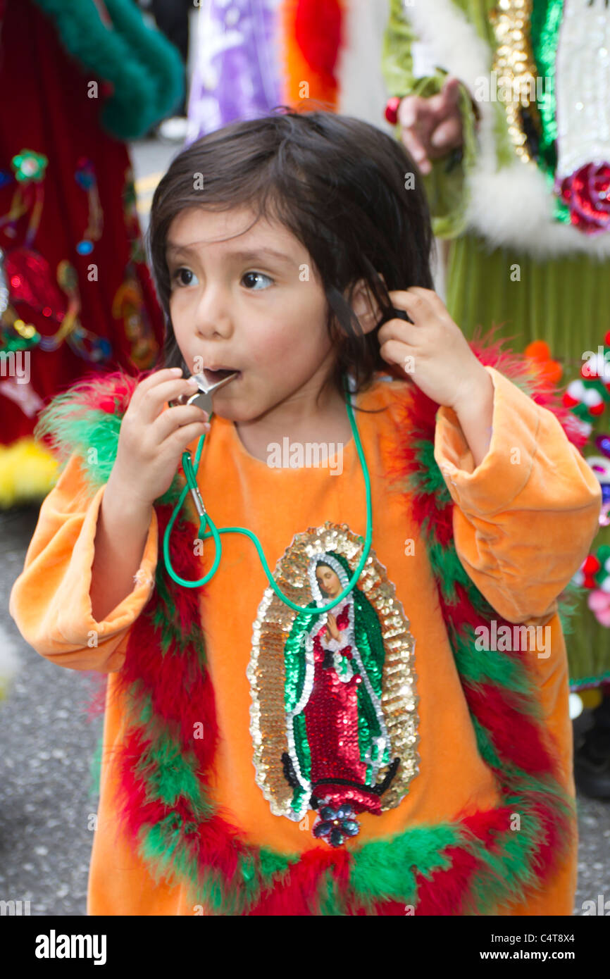 A young Mexican-American boy in a brightly colored costume blowing a whistle in the 2011 Cinco de Mayo parade in New York City Stock Photo