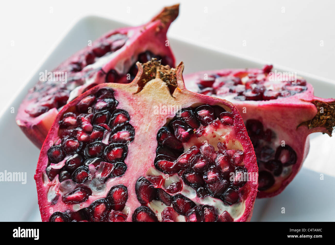 A pomegranate cut open into sections Stock Photo