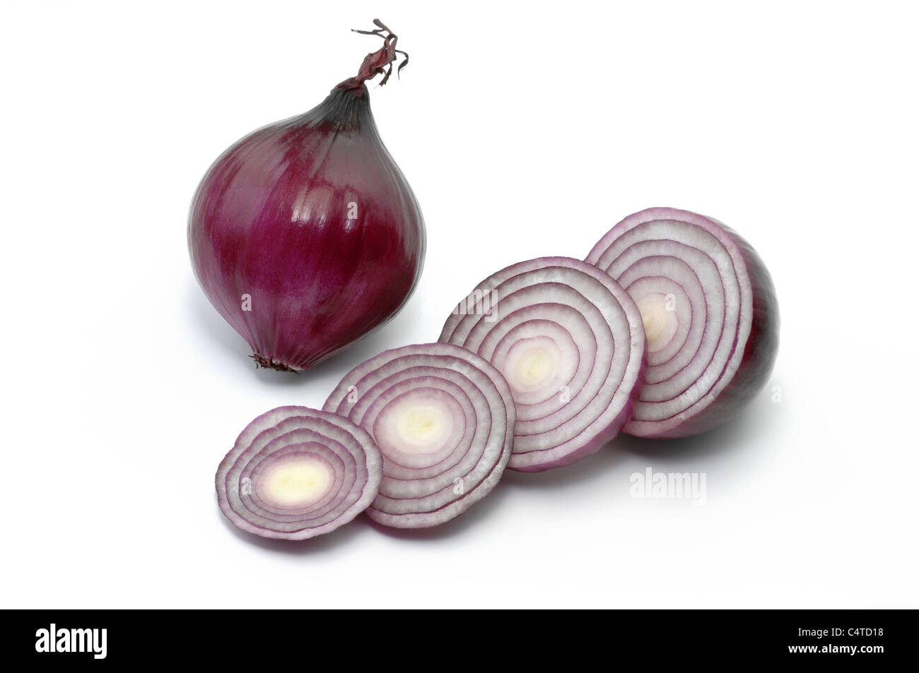 Garden Onion (Allium cepa). Red onion, whole and sliced. Studio picture against a white background. Stock Photo