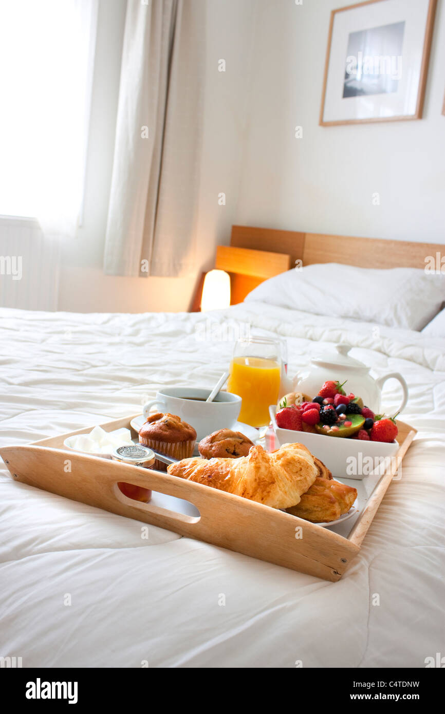 breakfast tray set up on a bed with healthy foods and drink Stock Photo