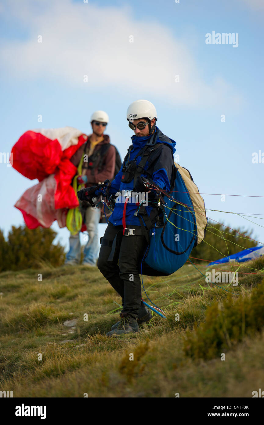 Male paraglider pilot preparing for launch wearing old fashioned flying goggles. Stock Photo