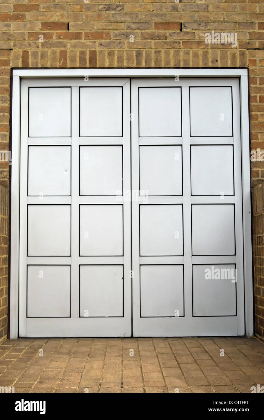 closed double door with no exterior handle set into a brick wall Stock Photo
