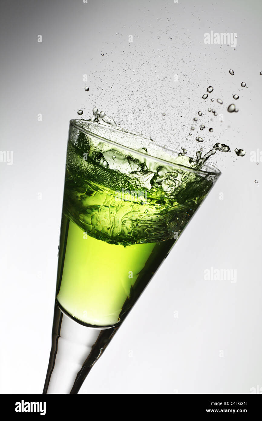 Splash in a glass, green absinthe. Stock Photo