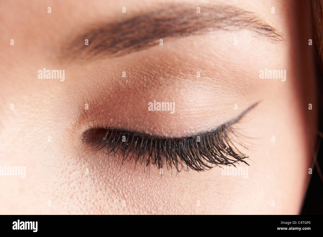 close up of womans brown eye lid with false eye lashes Stock Photo