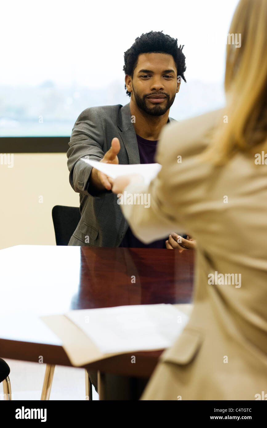 Man handing prospective employer - Man Handing Prospective Employer His Resume During Job Interview C4TGTC 