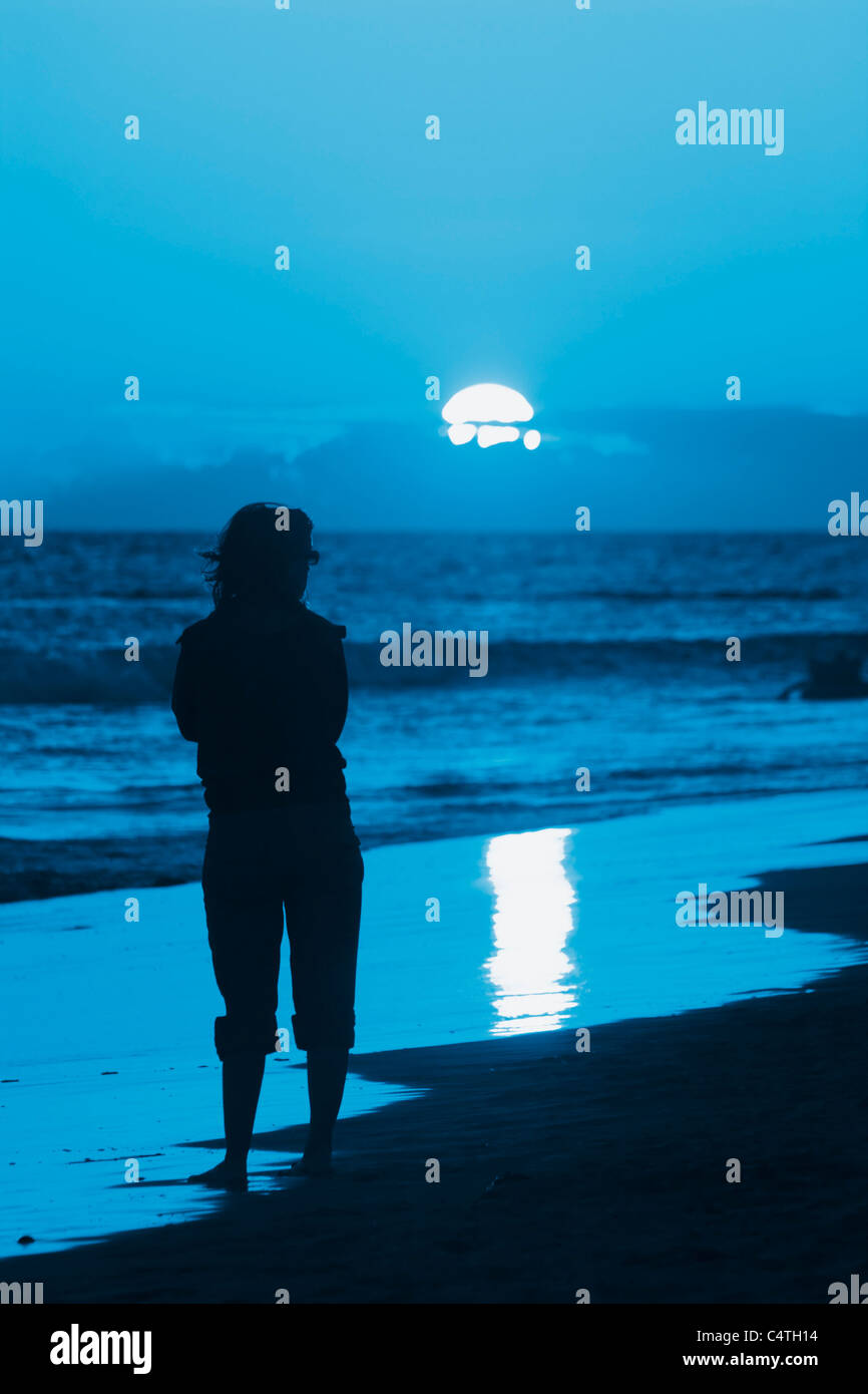 Woman on beach at sunset Stock Photo - Alamy