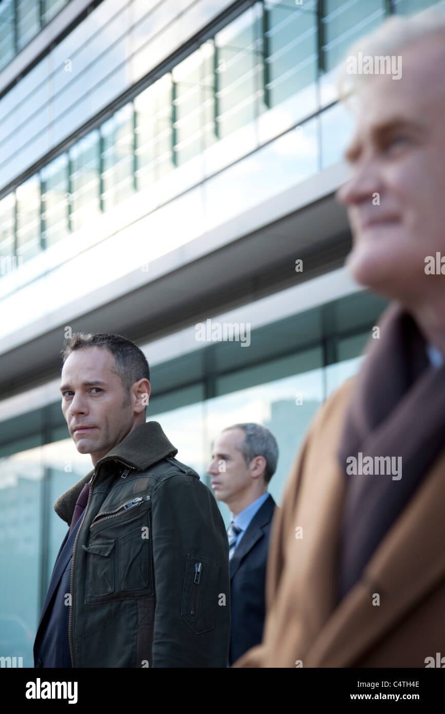 Man In Building Businessmen standing in front of building Stock Photo - Alamy