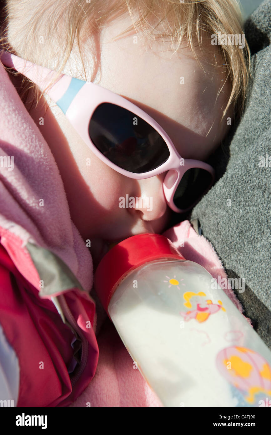 Baby girl lying down, drinking milk from bottle Stock Photo Alamy