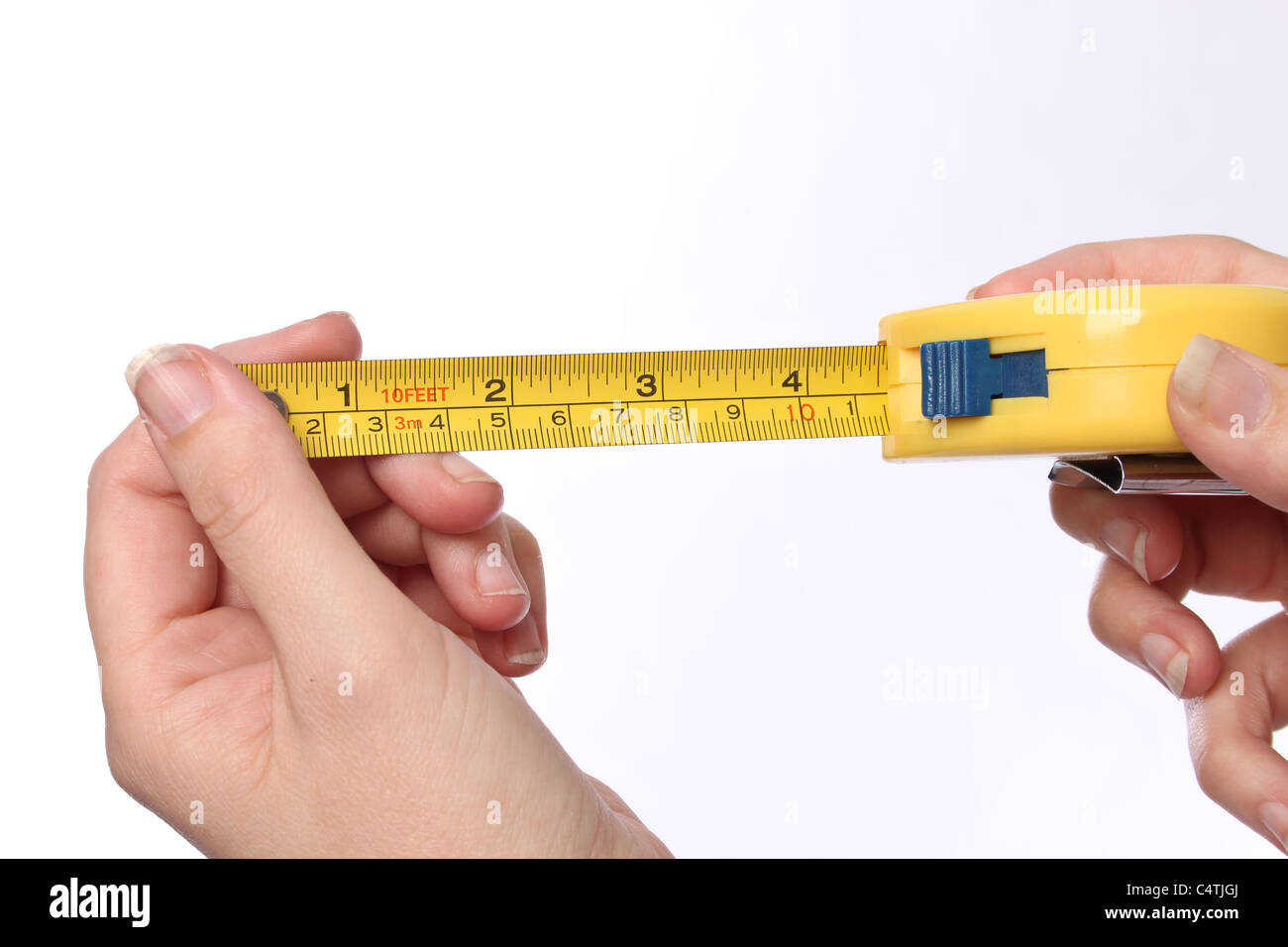 shot of two hands stretching out a yellow tape measure Stock Photo