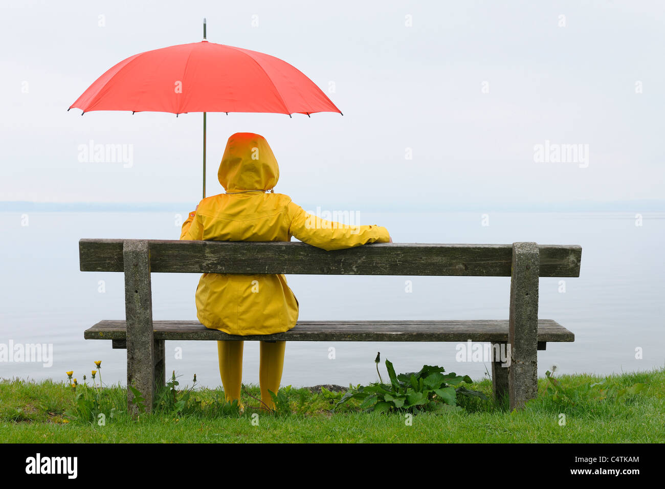 Women sitting on Bench with Umbrella, Lake Chiemsee, Bavaria, Germany Stock Photo
