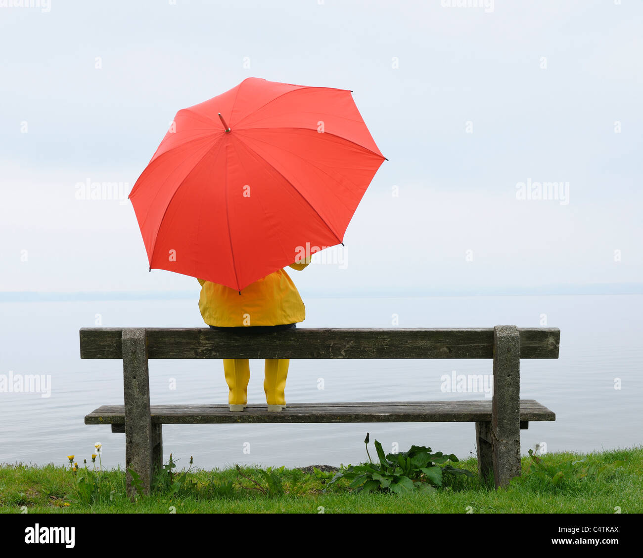 Women sitting on Bench with Umbrella, Lake Chiemsee, Bavaria, Germany Stock Photo