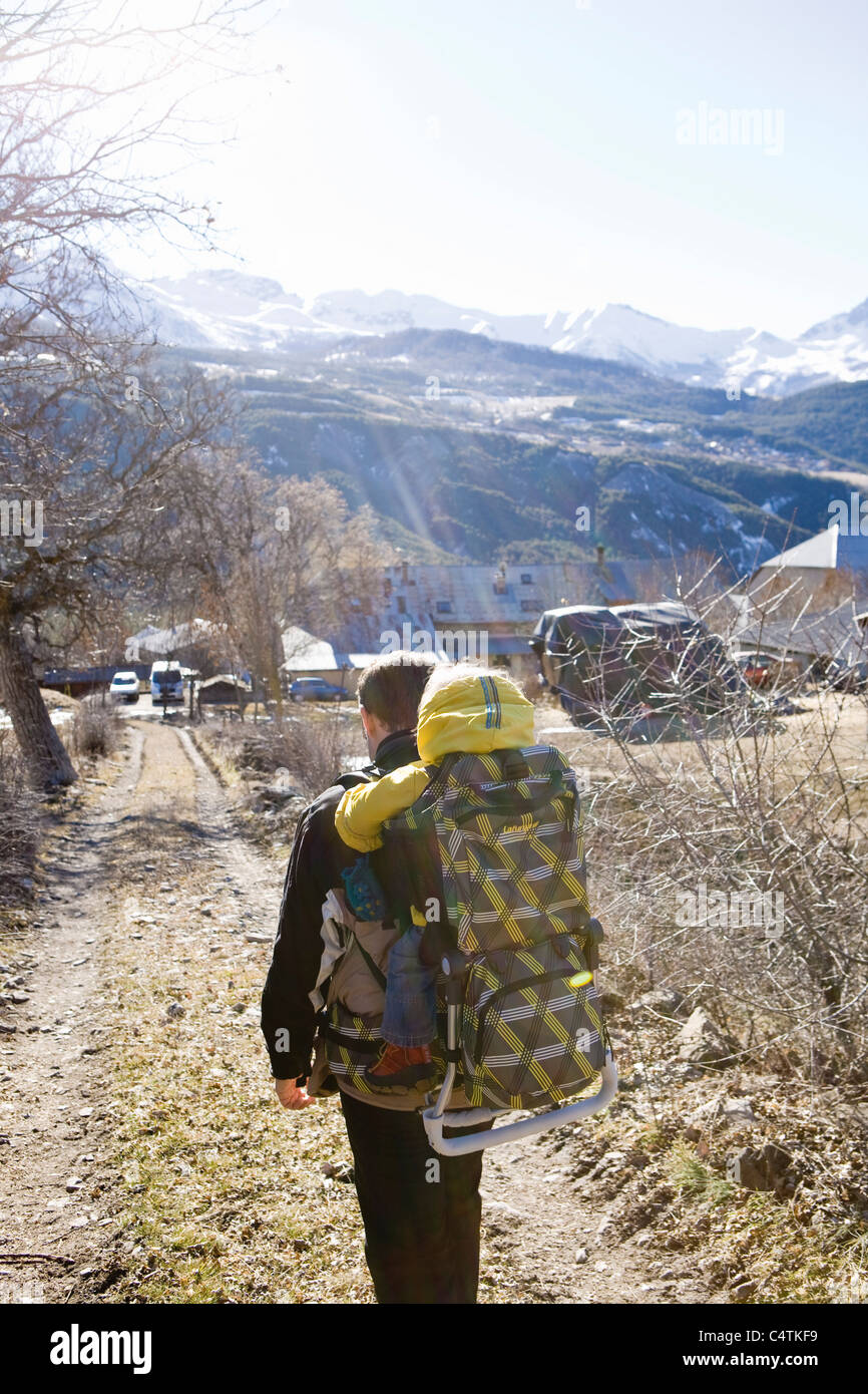 Father hiking on trail, carrying baby in backpack Stock Photo Alamy