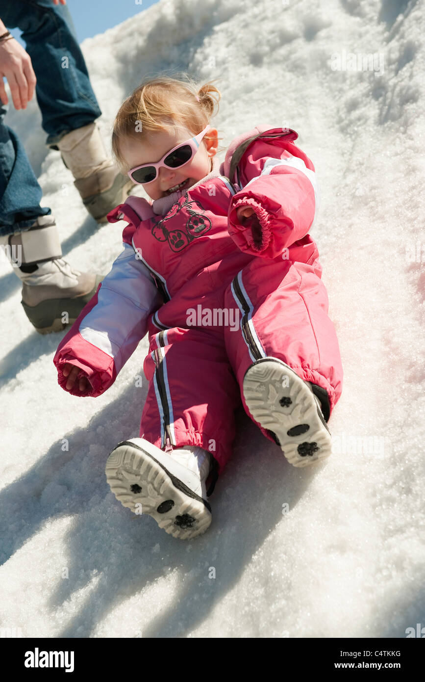 Toddler girl in snow suit sitting on snow Stock Photo Alamy