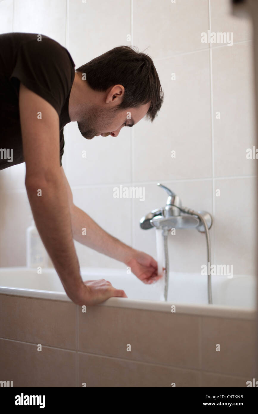 Man testing water temperature Stock Photo