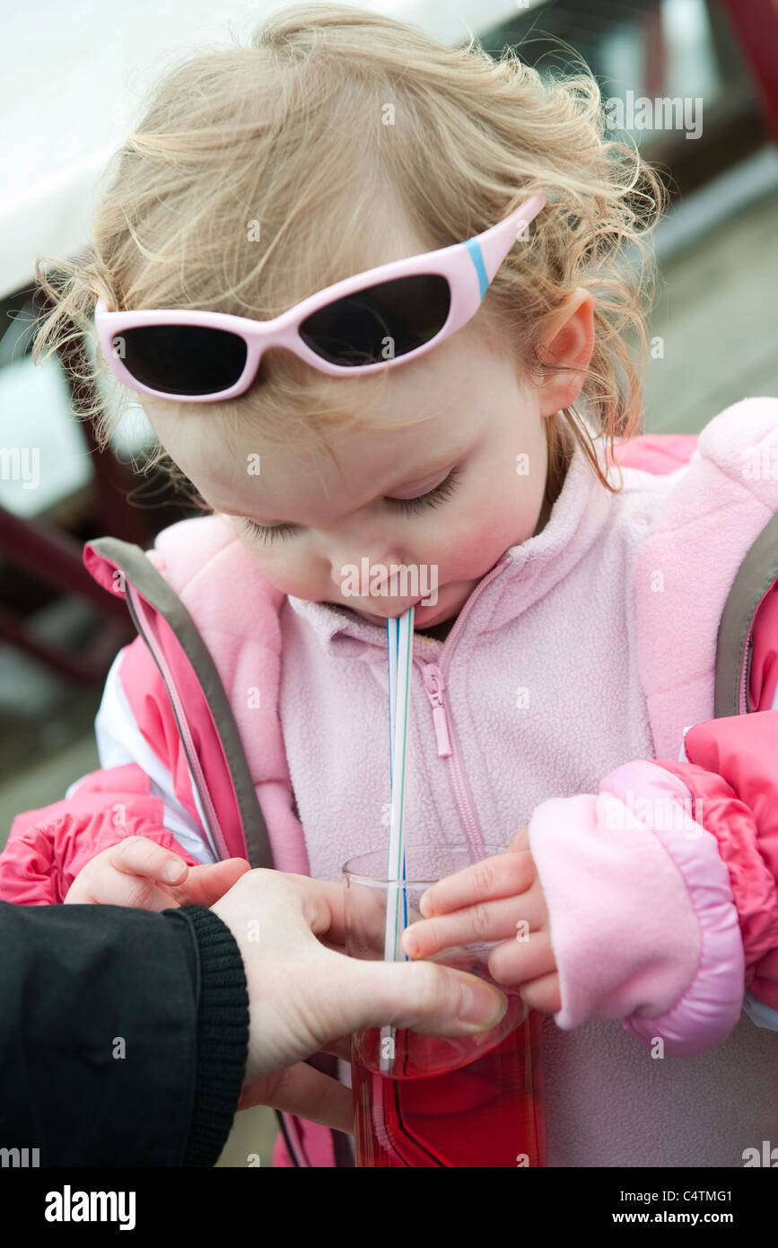 Toddler girl drinking juice with straw Stock Photo Alamy