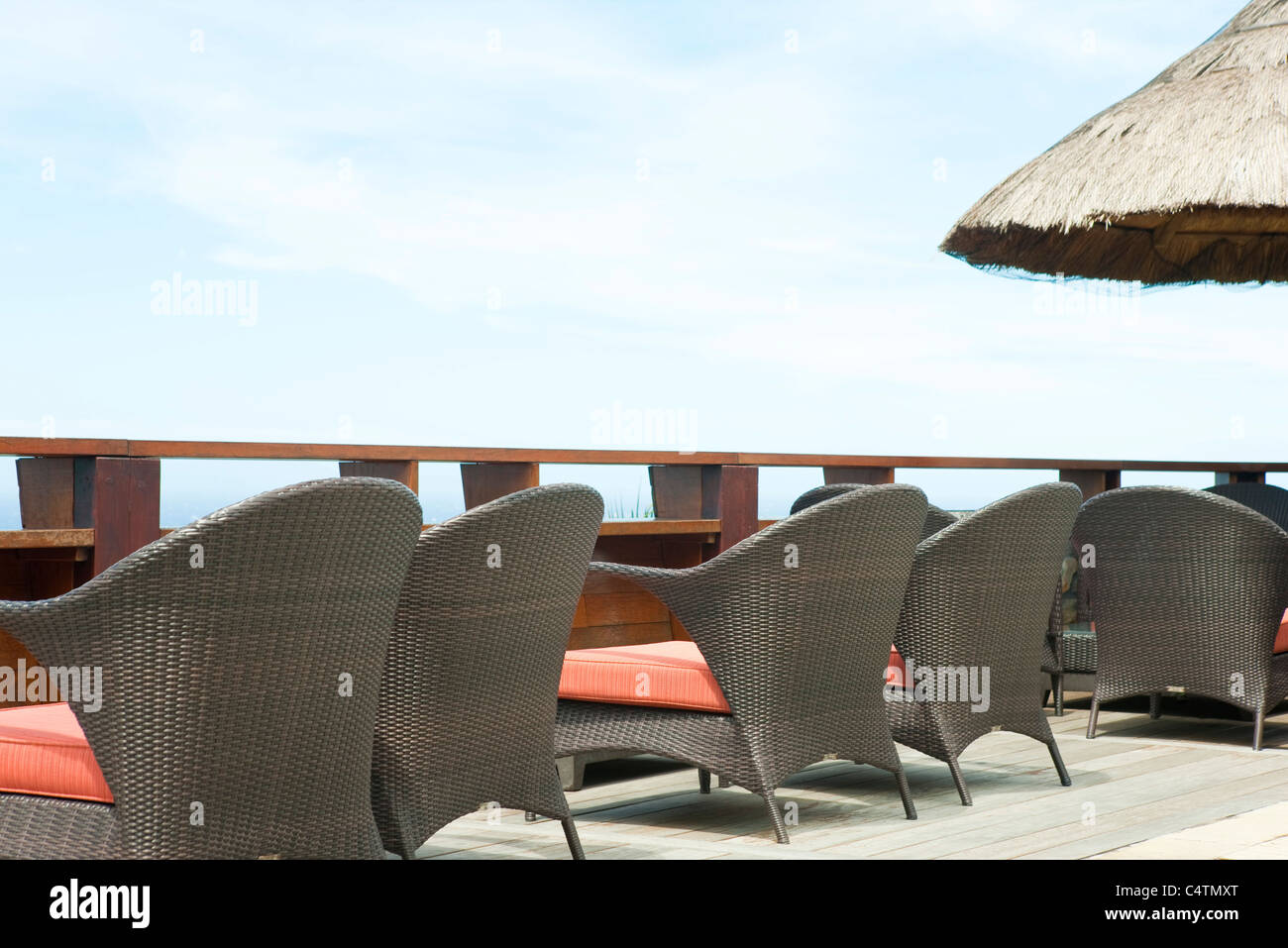 Wicker chairs lined up along deck Stock Photo - Alamy