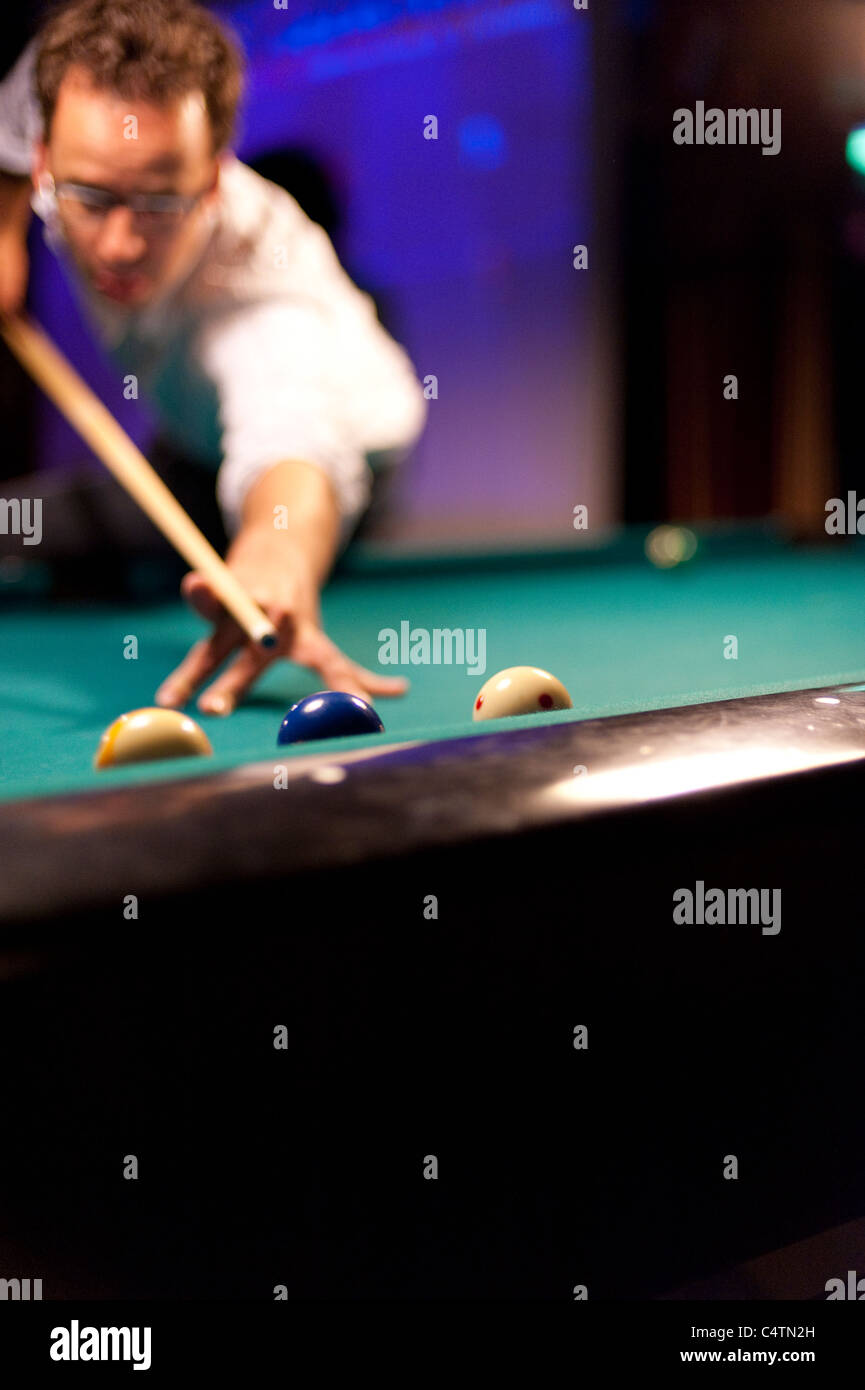 Young man playing eight ball billiards in a bar Stock Photo