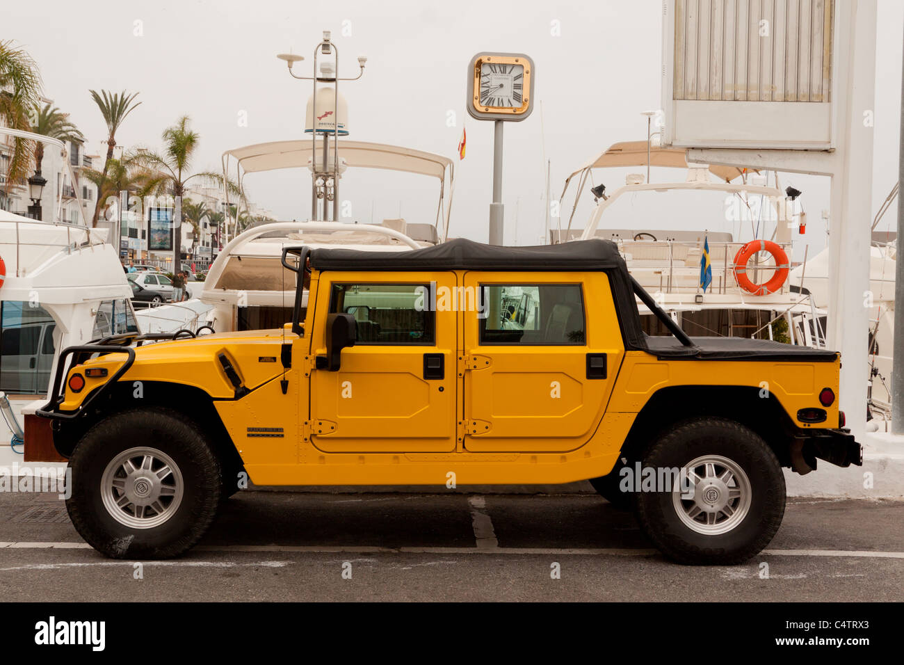 Bright Yellow Hummer SUV on Puerto Banus Harbour, Marbella, Spain Stock Photo