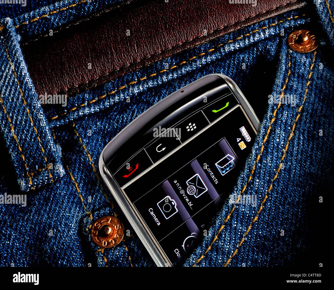 CLOSEUP OF CELL PHONE DEVICE PARTLY TUCKED INTO BLUE JEANS POCKET Stock Photo